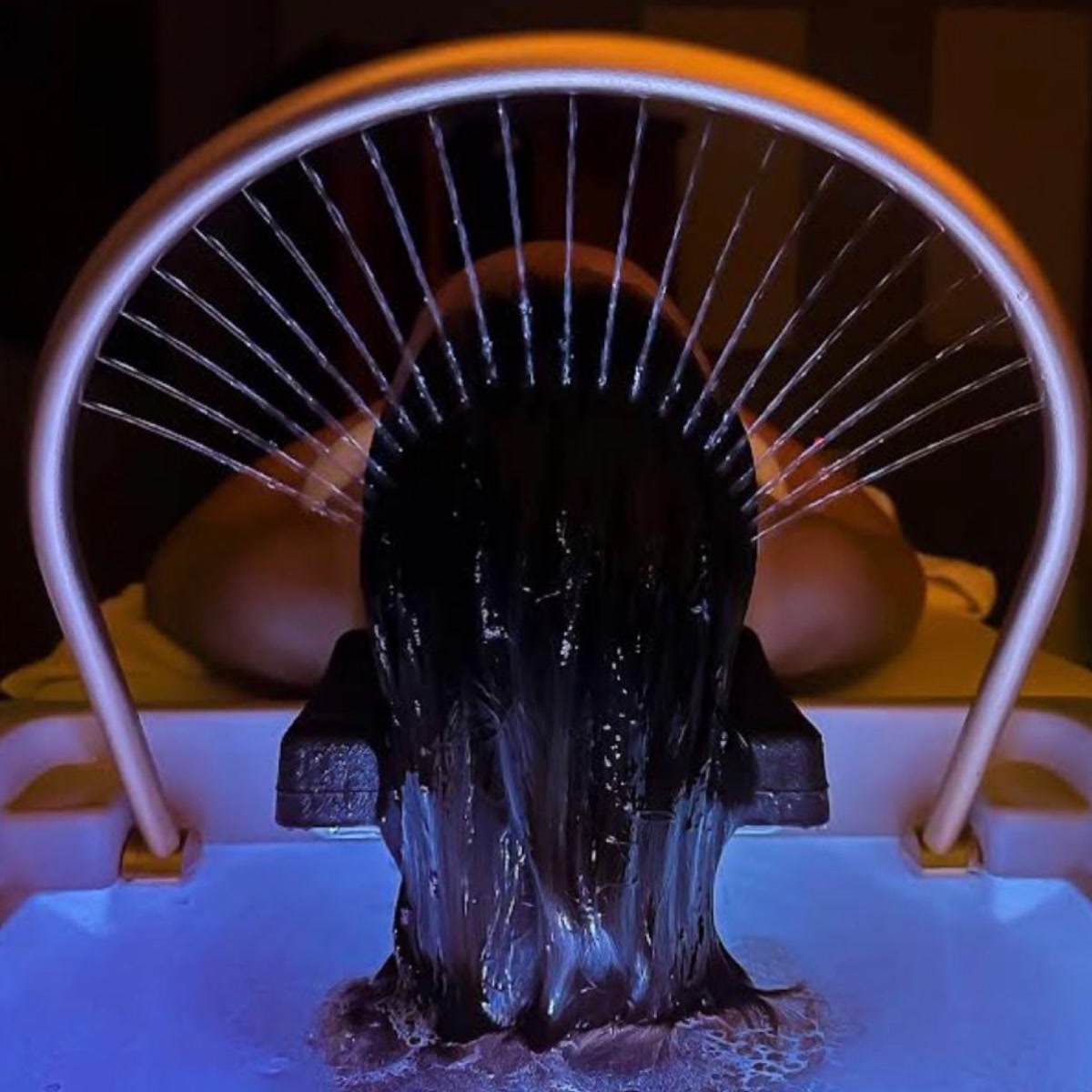 Water arc rinsing the hair during the luxury head spa ritual